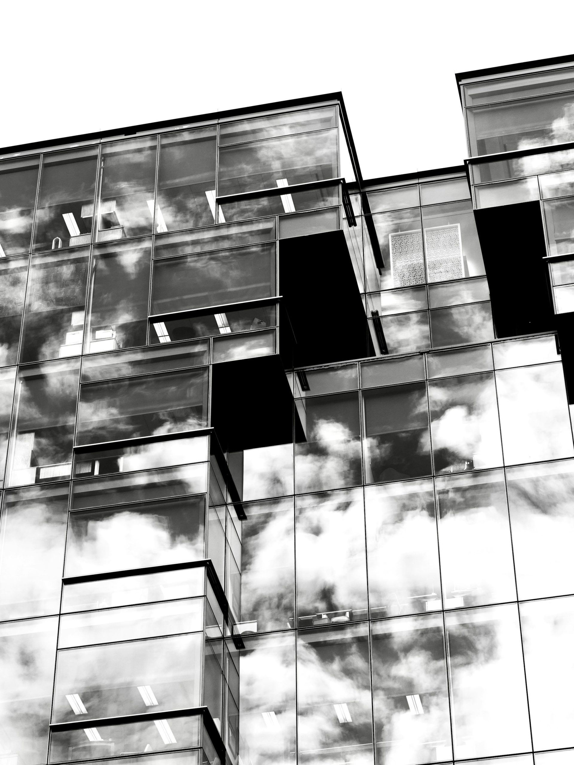 Façade en verre reflétant les nuages, noir et blanc